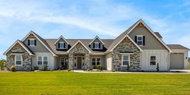 Large home with brownstone exterior and brown siding along top portion of home and white lower half.