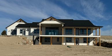 Exterior two story patio home with wood pillars and white batten board siding