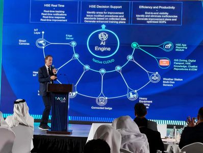 Presenter explaining AI-driven HSE solutions on a large screen at a conference.