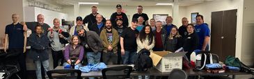 Group of people gathered in a room, smiling at the camera.