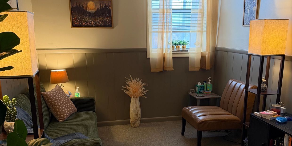 Cozy living room corner with warm lighting and plants.