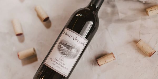 A bottle of Hansen Vineyards Cabernet Sauvignon surrounded by wine corks.