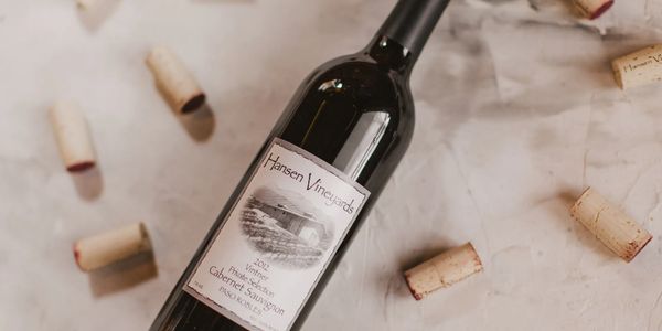 A bottle of Hansen Vineyards Cabernet Sauvignon surrounded by wine corks.