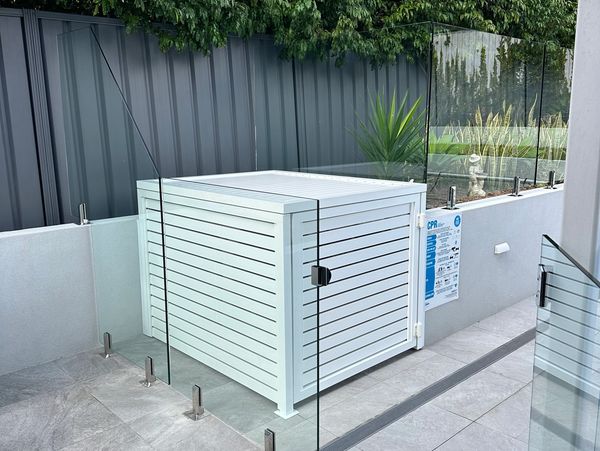 Modern outdoor area with glass fencing and a white storage box.