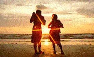 Silhouettes of two people standing on the beach