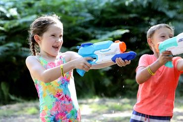 Children having fun with water guns outdoors.