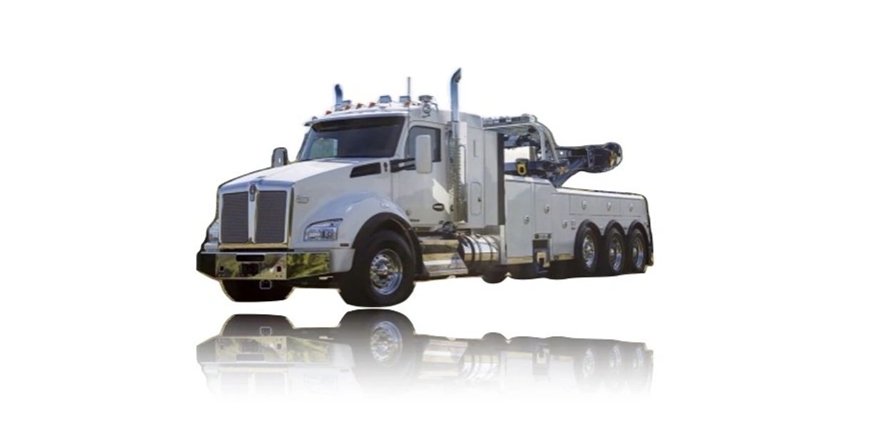 White heavy-duty tow truck with multiple wheels and reflective surface.