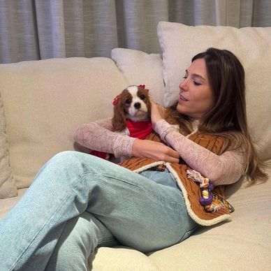Two Cavalier puppies snuggled in a wicker basket Fluffy Cavalier puppy sitting in green grass.