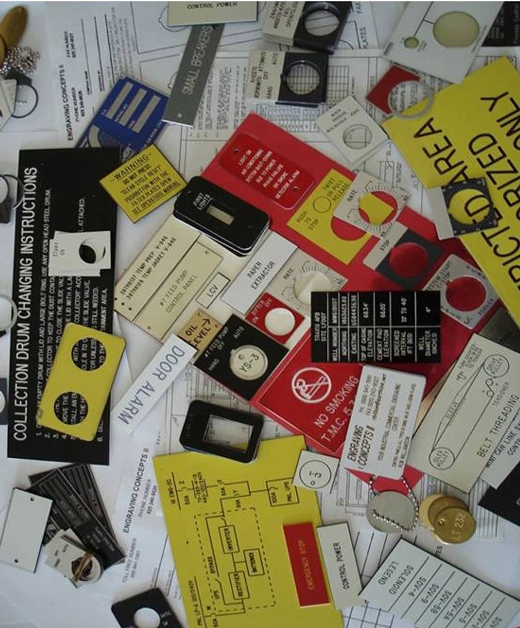 Various industrial labels and instruction plates scattered over technical documents.