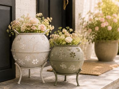 Decorative flower pots with flowers near a door.