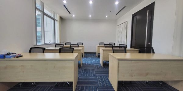 Empty office room with desks and chairs arranged neatly.