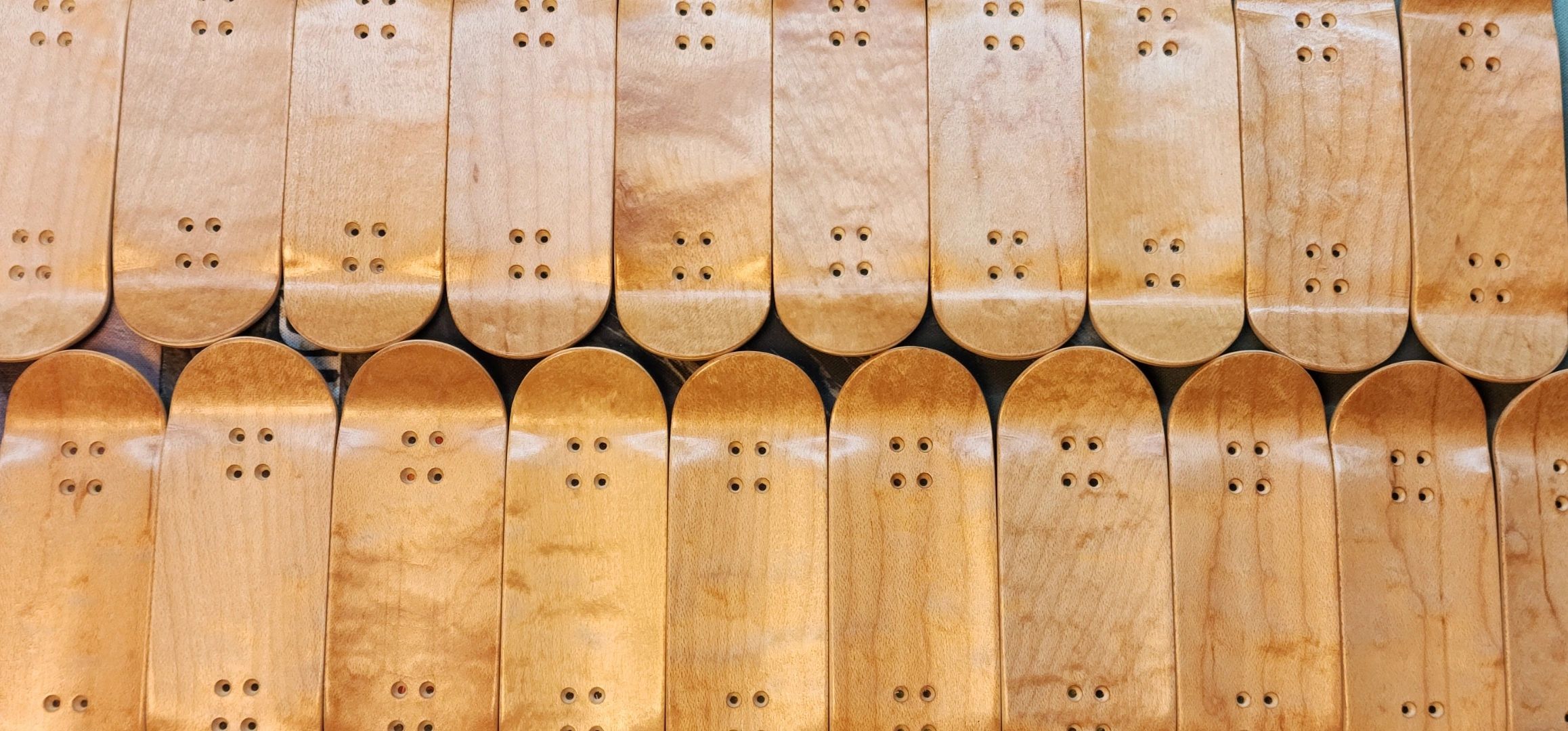 Rows of wooden skateboard decks without wheels.