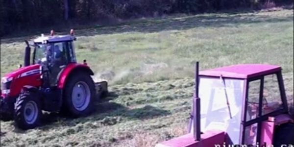 Two tractors working in a field on a sunny day.