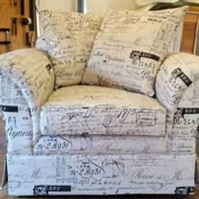 Armchair with vintage script fabric upholstery in a cozy room.