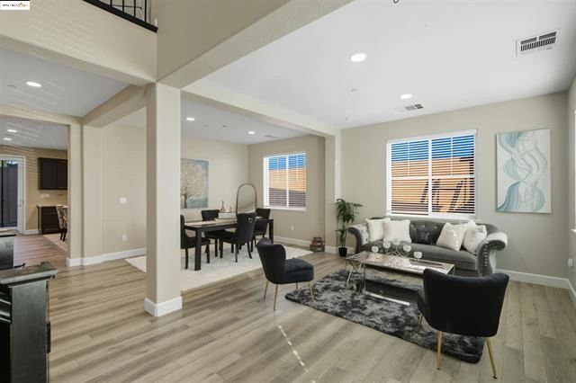 Modern open living and dining room with sleek furniture.