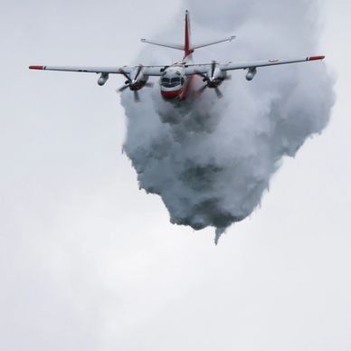 Firefighting plane releasing water from the sky.