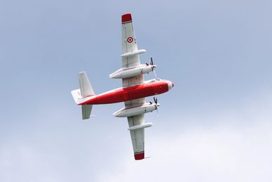 Red and white airplane flying in the sky.