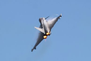 Jet fighter ascending with afterburners on.