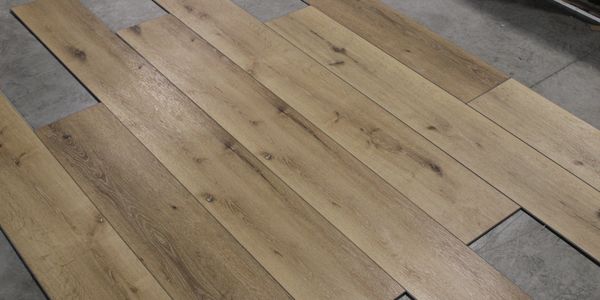 Wooden floor planks laid out on concrete for display and demonstrating installation process.