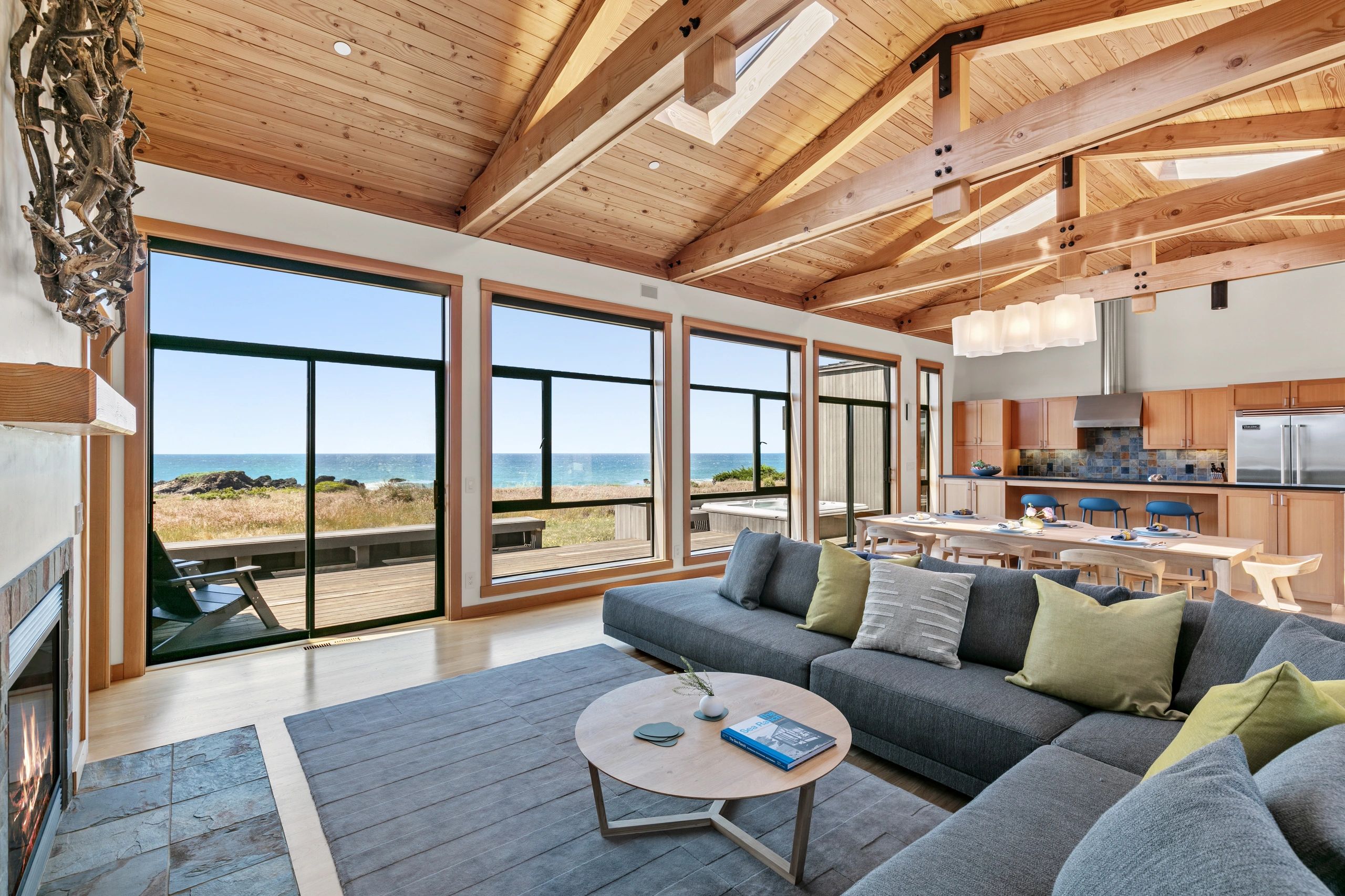 Cozy living room with ocean view and wooden ceiling.