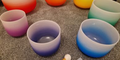 A set of coloured crystal singing bowls