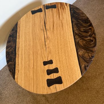 Round wooden table with contrasting wood grain patterns.