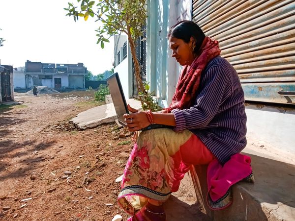 African woman in traditional clothes looking at the laptop