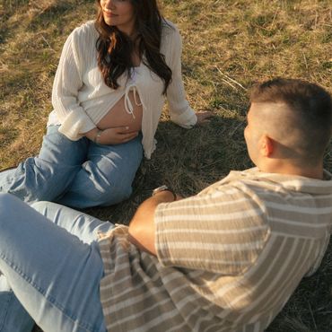 Couple enjoying a sunny day outdoors, woman showing her pregnancy.