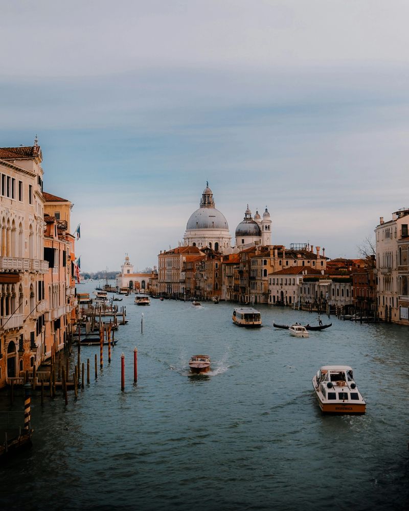 Scenic view of Venice, Italy featuring the Grand Canal, historic architecture, gondolas, and the iconic Santa Maria della Salute basilica—one of Europe’s top luxury travel destinations.