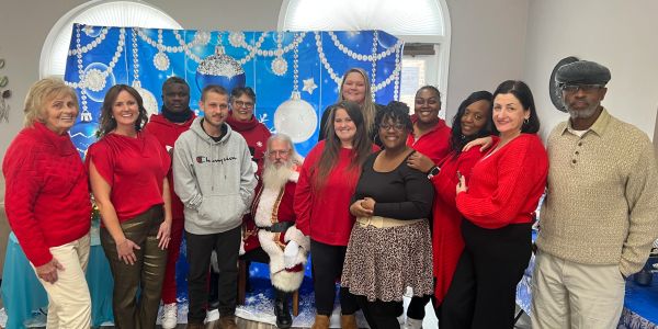 A group of people posing with Santa Claus in a festive setting.