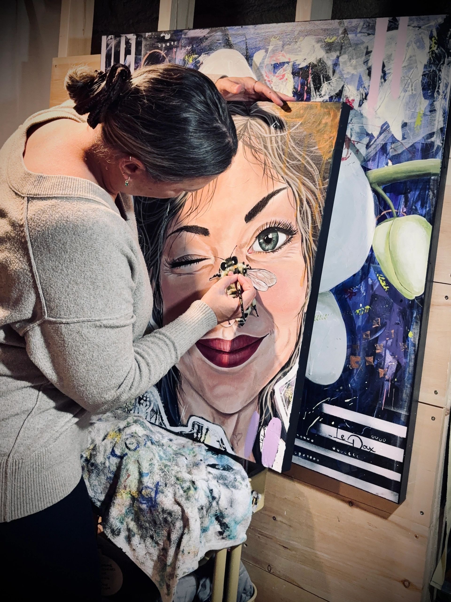 Une femme peint un portrait réaliste avec une abeille.