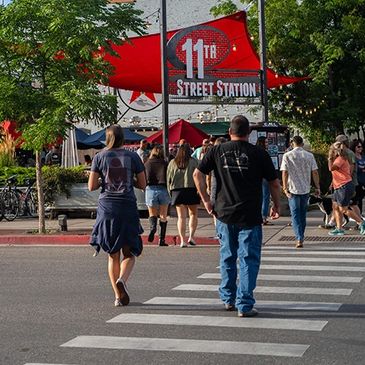 People walking towards 11th Street Station on a sunny day.