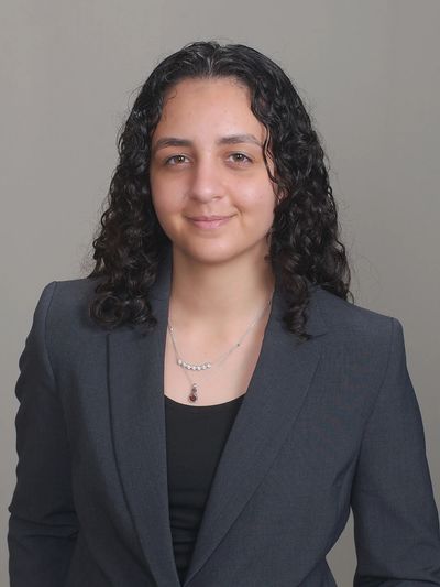 Professional woman with curly hair in a blazer.