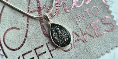 Teardrop-shaped pendant with glittery interior.