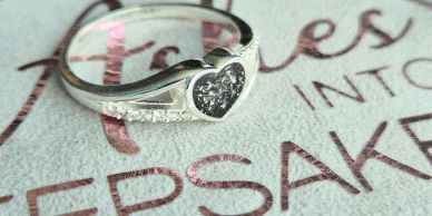 Silver heart-shaped ring with diamonds.