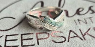 Silver ring with a unique design and small stones.