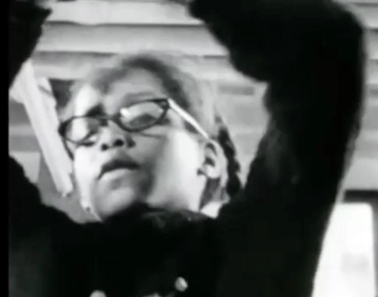 Young girl wearing glasses in a black and white photo.