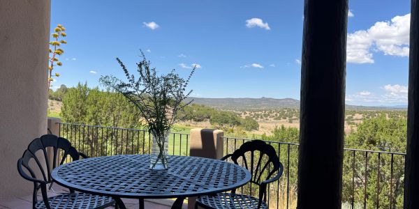 A patio table with two chairs overlooking a scenic landscape.