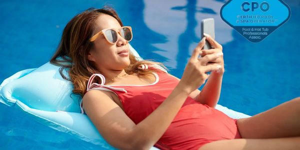 Woman in red swimsuit relaxing on pool float with phone and sunglasses.
