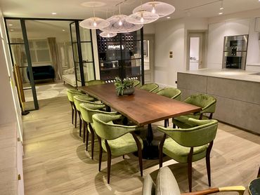 Modern dining room with green chairs and wooden table.