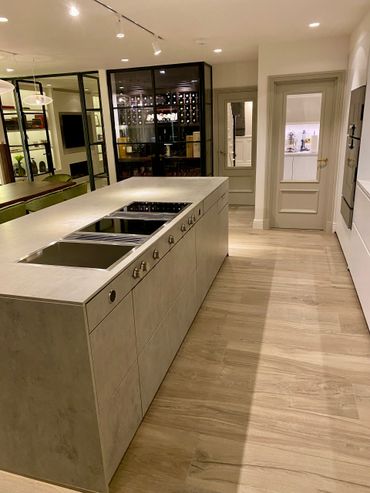 Modern kitchen with sleek island and built-in stovetop.