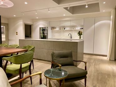 Modern kitchen and dining area with green chairs and minimalist design.