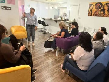 Group meeting in a cozy living room with a woman speaking.