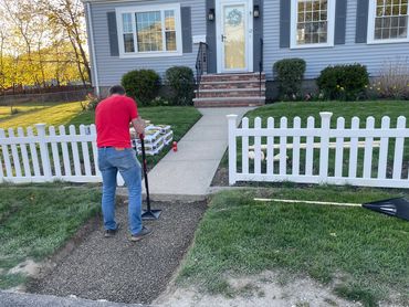 Handyman prepping ground for concrete walkway