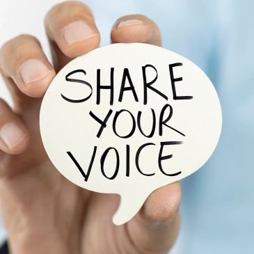 Hand holding a speech bubble with 'SHARE YOUR VOICE' text.