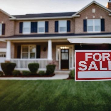 A house with a 'For Sale' sign on the lawn.