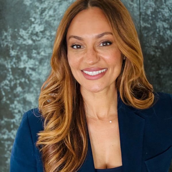 Smiling woman with long hair in blue blazer.