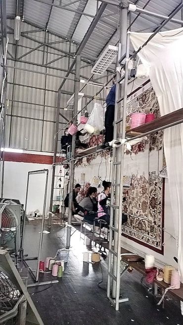 คนทำงานกับเครื่องทอผ้าขนาดใหญ่ในโรงงาน