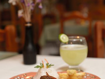 A plated meal with rice, meat, and fries, accompanied by a lime drink.