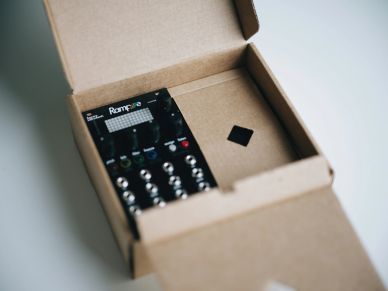 A small electronic device inside an open cardboard box.